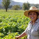 Head farmer Maria Rodriguez smiling among crops